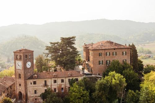 an old building with a clock tower and a town at Castello di Casalborgone, Luxury Italian Castle Hotel in Casalborgone
