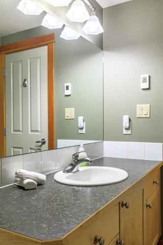 a bathroom with a sink and a large mirror at Summit at The Lodges of Canmore in Canmore