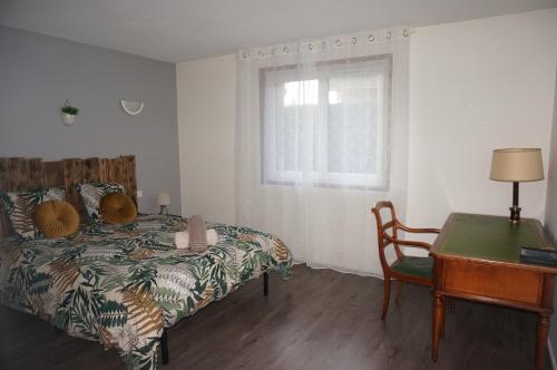 une chambre avec un lit, un bureau et une fenêtre dans l'établissement l'appartement village, à Saint-Martin-d'Uriage
