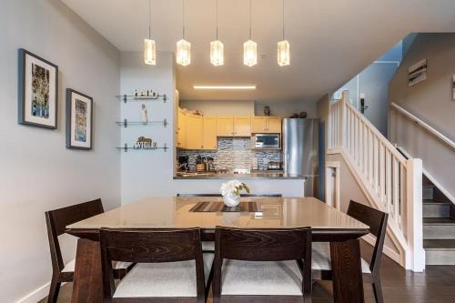 a dining room with a table and chairs and a kitchen at Mountain Memories Family Fun at The Lodges in Canmore