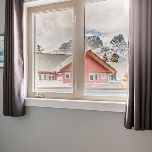 a window with a view of a snow covered mountain at Mountain Memories Family Fun at The Lodges in Canmore