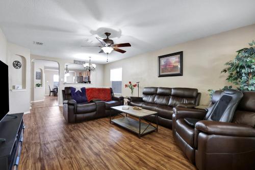 a living room with leather furniture and a ceiling fan at Texas Star - A Birdy Vacation Rental in San Antonio