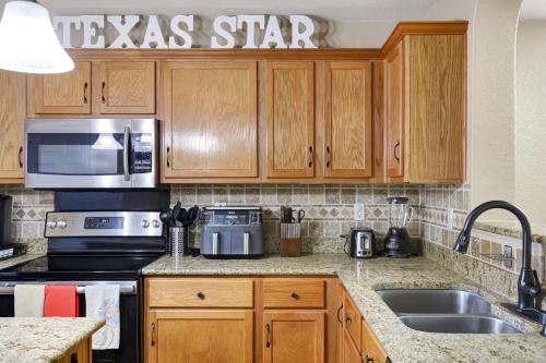 a kitchen with wooden cabinets and stainless steel appliances at Texas Star - A Birdy Vacation Rental in San Antonio