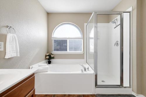 a white bathroom with a shower and a sink at Texas Star - A Birdy Vacation Rental in San Antonio