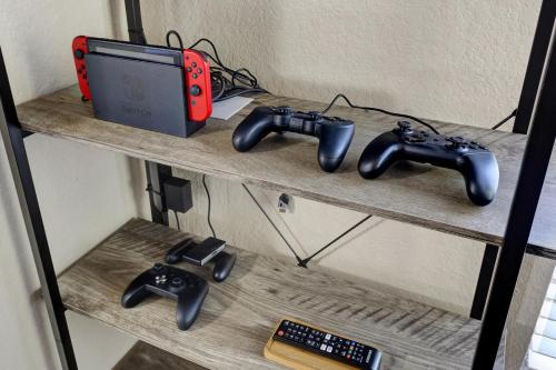 a shelf with three video game controllers and a router at Texas Star - A Birdy Vacation Rental in San Antonio
