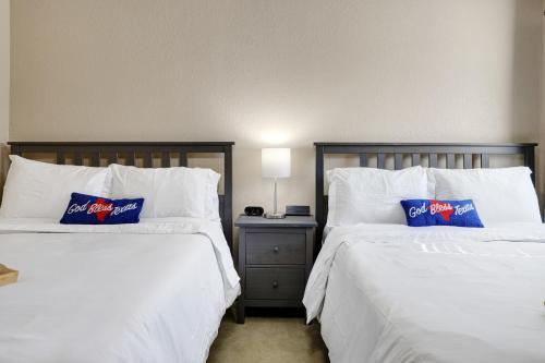 two beds with white sheets and blue pillows in a room at Texas Star - A Birdy Vacation Rental in San Antonio