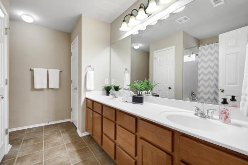 a bathroom with a sink and a large mirror at Texas Star - A Birdy Vacation Rental in San Antonio