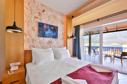 a bedroom with a large bed and a balcony at Atalante Hotel in Kas