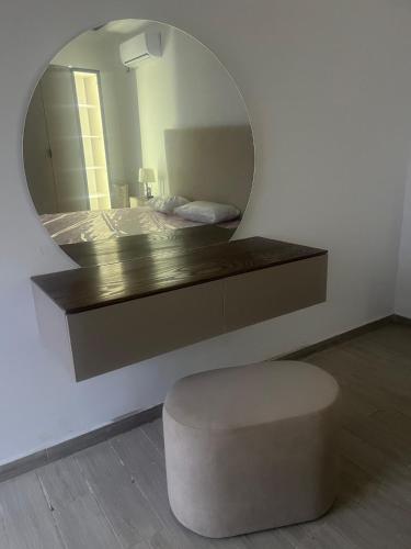 a bedroom with a bed with a mirror and a stool at Villa Léann in Mezraya