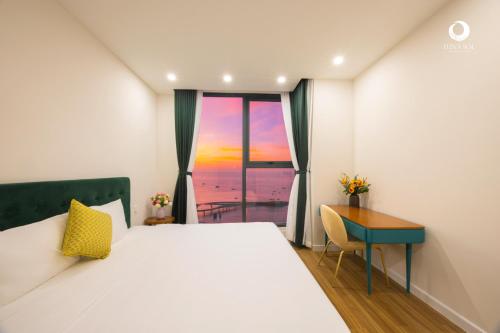a bedroom with a bed and a desk and a window at Luna Sol Villas - Dedicated Care Until Check Out in Phu Quoc