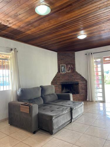 a living room with a couch and a fireplace at Chacara Paraiso do Rio Verde in Campo Largo