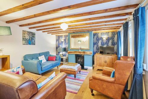 ein Wohnzimmer mit Sofa, Sesseln und Fernseher in der Unterkunft Host & Stay - Anvil Cottage in Kirkbymoorside