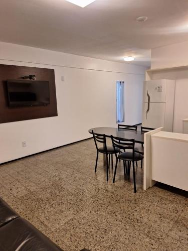 a dining room with a table and chairs and a refrigerator at Hotel Brasil Tropical in Fortaleza