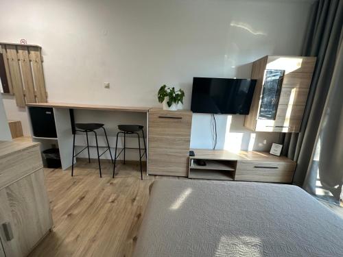 a bedroom with a desk with a tv and a bed at Apartmán BB-Centrum1 in Banská Bystrica
