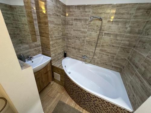a bathroom with a bath tub and a sink at Apartmán BB-Centrum1 in Banská Bystrica