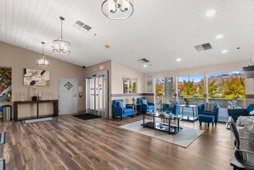 a living room with blue chairs and a table at Clarion Pointe Wenatchee in Wenatchee