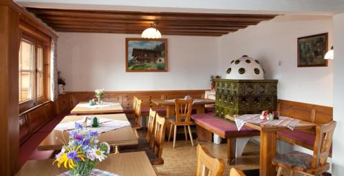 アルテンマルクト・イム・ポンガウにあるBerggasthof-Ferienbauernhof Habersattの木製のテーブルと椅子、花のあるレストラン