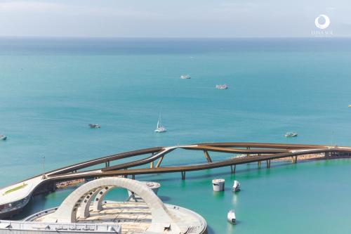 a bridge in the water with boats in the ocean at Luna Sol Villas - Dedicated Care Until Check Out in Phu Quoc