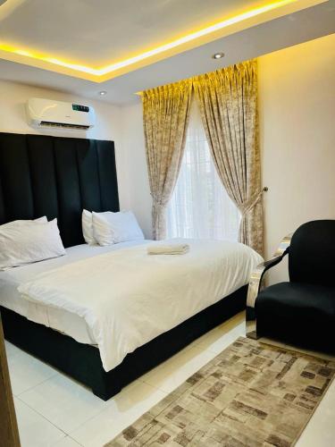 a bedroom with a large bed and a window at Diaggello Homex Apartment in Lekki
