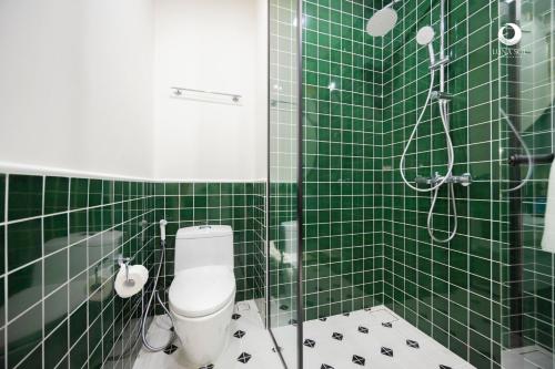 a green tiled bathroom with a toilet and a shower at Luna Sol Villas - Dedicated Care Until Check Out in Phu Quoc