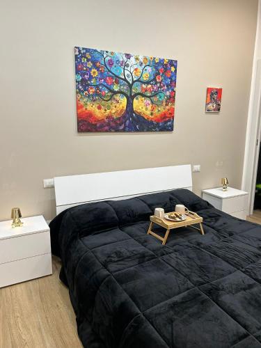 a bedroom with a black bed and a painting on the wall at Sweet dreams in Palermo