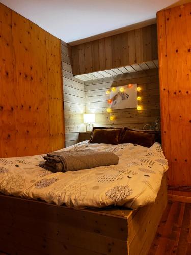 a bedroom with a large bed with a wooden wall at Maison de village avec vue sur les montagnes et jardin privatif in Montauban-de-Luchon