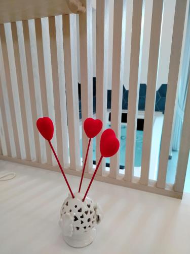 a white vase with red hearts in a crib at Maruzzé luxury room in Albori