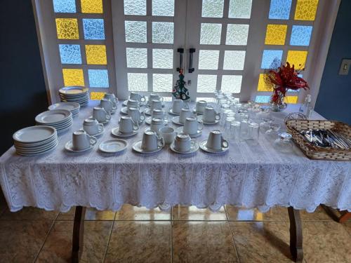 a table with cups and plates on it at ANC BOSQUE - 4min do Parque Capivari in Campos do Jordão