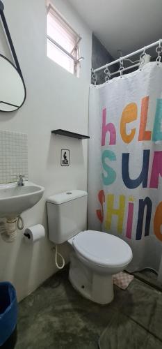 a bathroom with a white toilet and a sink at Di Pipa Rooms - Hidromassagem Externa in Pipa