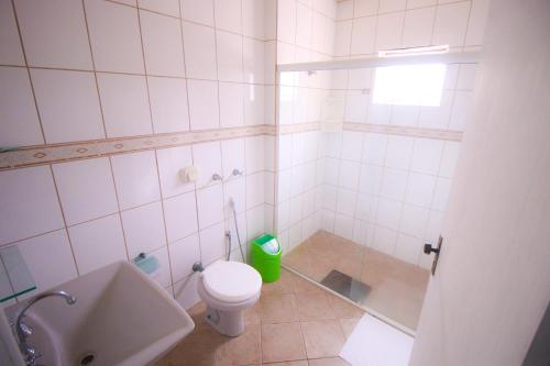 a white bathroom with a toilet and a shower at Premier Palace Hotel in Araranguá