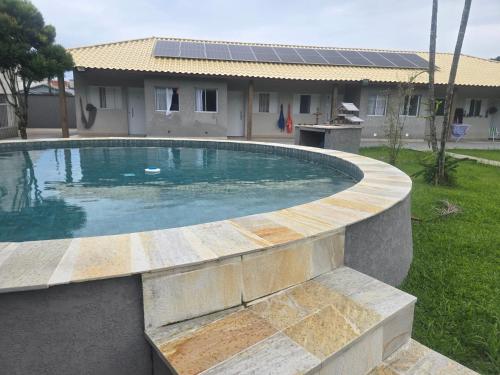 une piscine dans une cour avec une maison dans l'établissement Villa Serenità, à Peruíbe