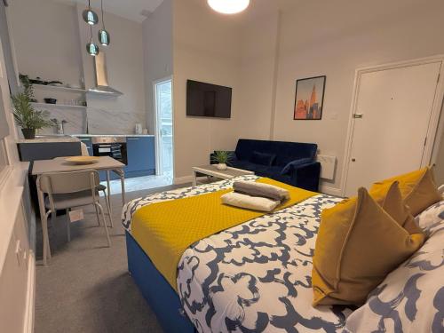 a bedroom with a king sized bed and a kitchen at Skyline Studios Maida-Vale in London