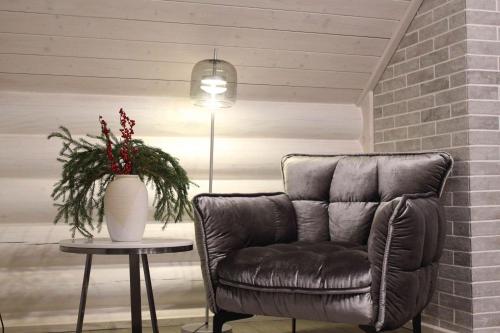 a leather chair and a table with a vase of flowers at Shypit Spa&Resort in Pilipets
