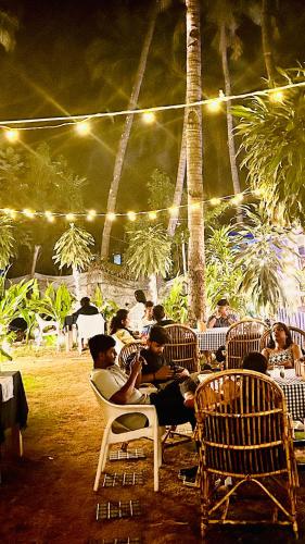 a group of people sitting in chairs under a tent at Garden Aroma Palolem, Beachside Hostel & Cafe Bar in Palolem