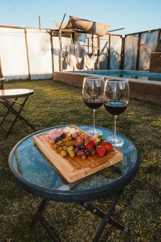 a table with two glasses of wine and a plate of food at La Finca de Vane in Valle de Guadalupe