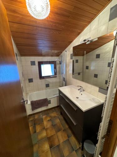 une salle de bain avec un lavabo et une baignoire dans l'établissement Le Pré Veillant, à Val Cenis