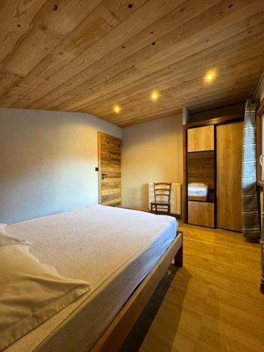 - une chambre avec un grand lit et un plafond en bois dans l'établissement Le Pré Veillant, à Val Cenis