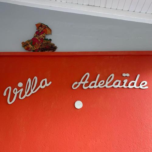 a red wall with alda adelaide written on it at Villa Adélaïde in Grand-Bourg