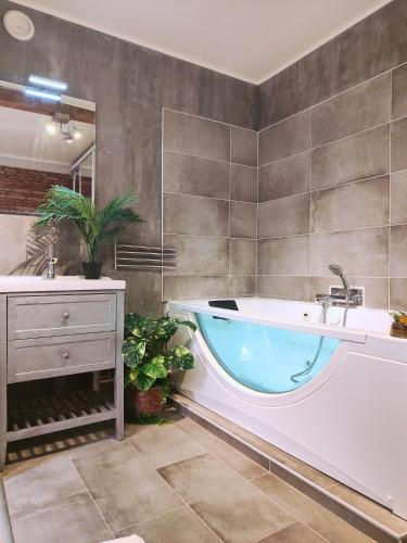 une grande salle de bain avec une baignoire et un lavabo dans l'établissement Cocoon'Inn Daurade, à Toulouse