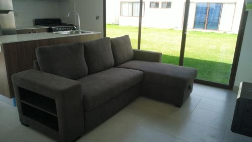 a living room with a couch and a kitchen at Casa Zona de Playa in Palo Verde
