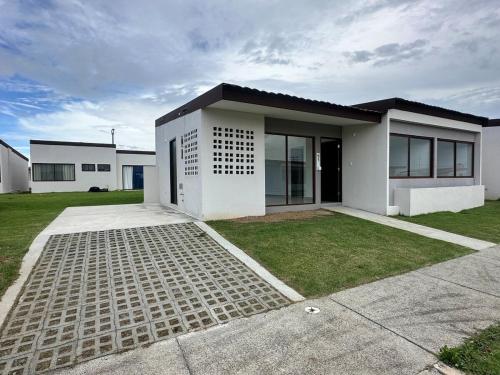 a white house with a driveway in front of it at Casa Zona de Playa in Palo Verde
