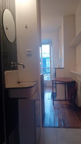 La salle de bains est pourvue d'un lavabo et d'une table. dans l'établissement Corazon de Paris, à Paris
