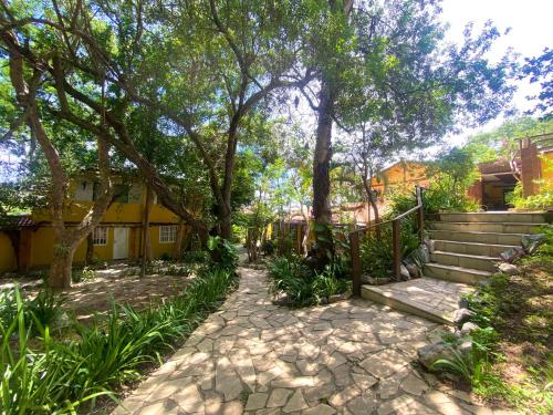a walkway in front of a house with trees at Paraíso Geribá in Búzios