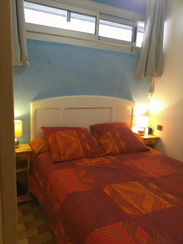 une chambre avec un grand lit avec un mur bleu dans l'établissement Bel Appartement Terrasse Vue Mer, à Port-Leucate