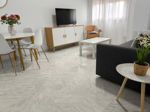 ein Wohnzimmer mit Sofa und Fernseher in der Unterkunft Apartamento acogedor - piscina - parking in Sevilla