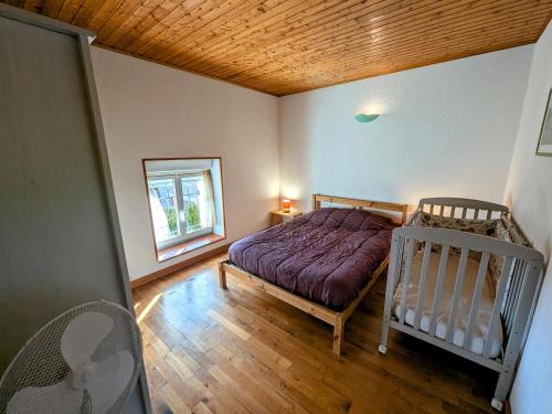 a bedroom with a bed and a crib in it at Gîte familial avec terrasse et espace enfants à Faymont - FR-1-583-370 in Faymont