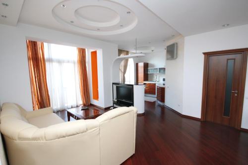 a living room with a white couch and a television at Real Home Apartments in Kiev Center in Kyiv