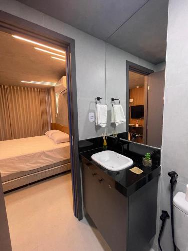 łazienka z umywalką i łóżkiem w obiekcie Storey Luxor Flats Caribessa Praia - Apt 002 Com SPA w mieście João Pessoa