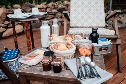 a wooden table with food and utensils on it at Pousada Borghetto – Charme e Exclusividade no Vale dos Vinhedos in Bento Gonçalves