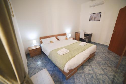 a bedroom with a bed with two towels on it at Aria di Sale Hostel in Trieste
